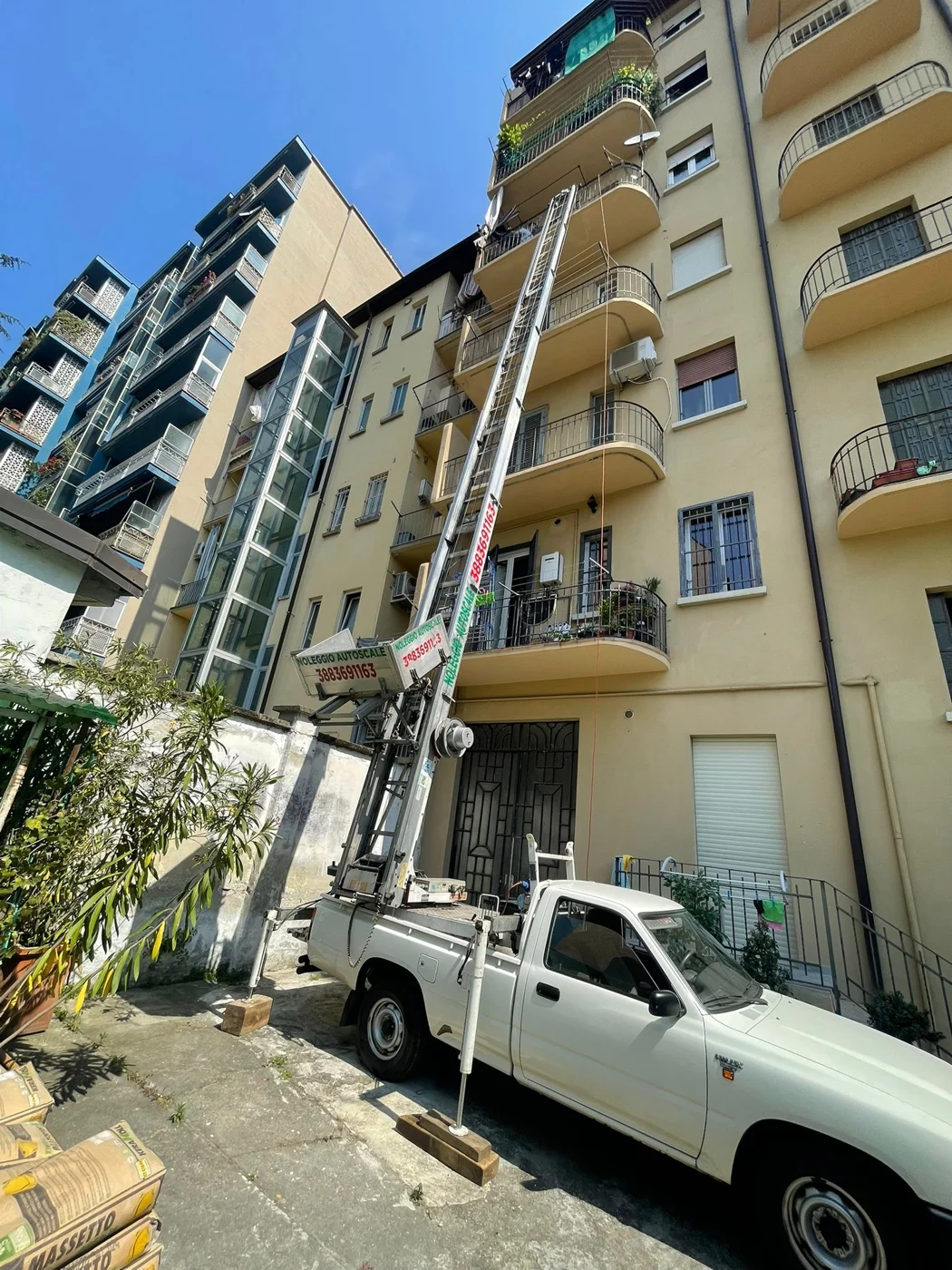Autoscala accanto a un edificio e furgone durante un servizio Traslochi Leo